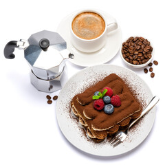 portion of Classic tiramisu dessert with raspberries and blueberries, cup of espresso and coffee maker isolated on white background with clipping path