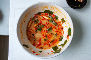 Tom Yum cups are left but broth on a white wooden table