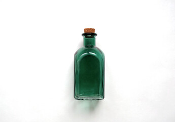 Old-fashioned green transparent glass bottle for medicine, essential oil, empty container with a cork on the white background