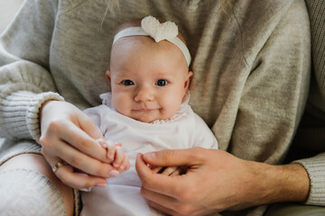 Close-up of a newborn baby in mom and dad's arms.
