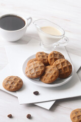 Coffee Butter Cookies, powdered with icing sugar, on a white wooden table.