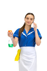 Talking phone. Portrait of female made, housemaid, cleaning worker in white and blue uniform isolated over white background. Copyspace for ad. Concept of professional occupation, job, emotions.