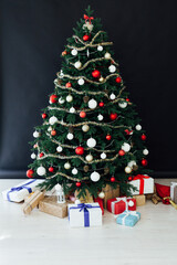 Festive room interior with stylish armchair and beautiful Christmas tree