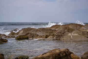 Fototapeta na wymiar waves crash on stones