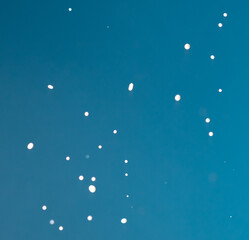 Splashes of white milk isolated on a blue background.