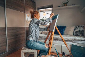 Fototapeta na wymiar Beautiful artist woman painting in her room.