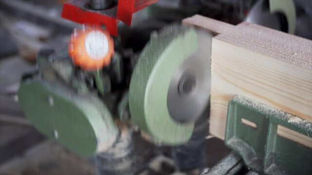 Close up view. A tenon saw is used on wooden plank in carpenter workshop. 