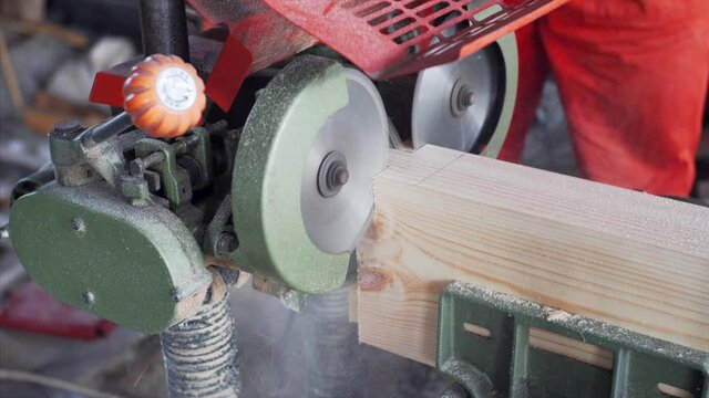 A tenon saw is used on wooden plank in carpenter workshop. Close view
