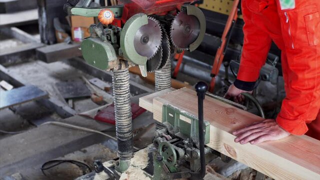A professional tenon saw is used on wooden plank in carpenter workshop