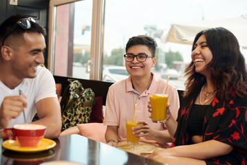 Meeting of friends. Three multi-ethnic friends are discussing something and laugh at it