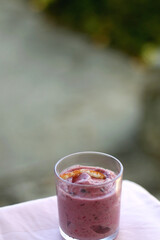 Banana and berry vegan nice cream, served in a garden. Selective focus.