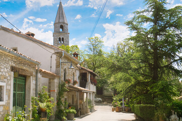 A beautiful street, pile of firewood and old historic houses decorated with flower pots in the medieval town of Roc in Istria, Croatia