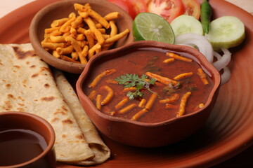 Dhaba style Sev bhaji/sabzi/curry made in tomato curry with gathiya shev, served with chapati/ roti.