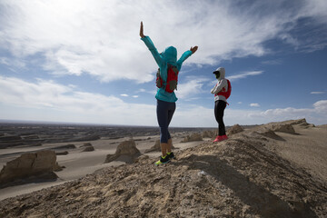 Two trail runners cross country running  on sand desert dunes