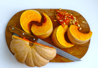 half pumpkin and cut with knife on kitchen board closeup photo