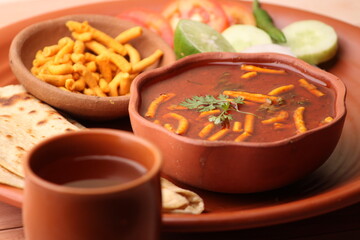 Dhaba style Sev bhaji/sabzi/curry made in tomato curry with gathiya shev, served with chapati/ roti.