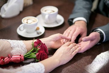 Young couple in love  holding hands, series in acafe, outdoors, wedding ceremony, with flowers. tender scenes with human hands