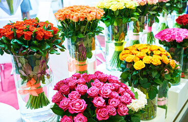 Colorful bouquets of roses on showcase of flower shop