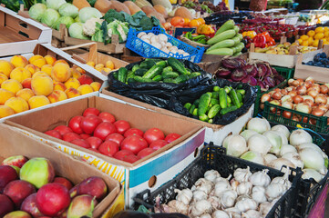 harvest of agricultural products at the farmers ' market is ready for sale. Farmers collected tomatoes, onions, garlic, cucumbers and other vegetables in boxes