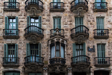Fototapeta na wymiar Barcelona, Catalonia, Spain, September 22, 2019. Details of the exterior historical buildings. Ancient bas-reliefs on the windows and walls. Architectural design elements.