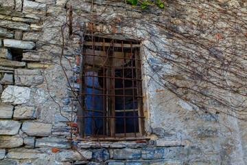 Fototapeta na wymiar An old window in a stone house on a street in Varenna, a small town on lake Como, Italy