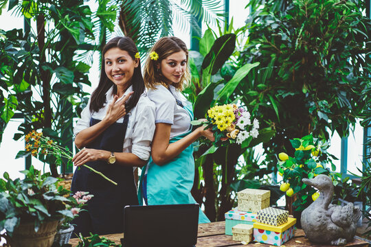 Smiling multiethnic female colleagues working in flower shop