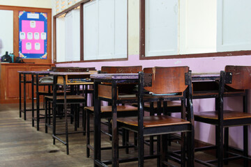 Student chairs and student desks by the window in class Educational equipment (In the classroom)