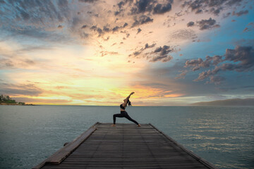 Fototapeta premium Young healthy woman practicing yoga on the bridge in the nature