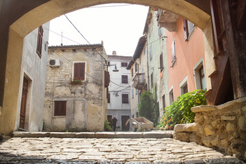 The town center with traditional historic houses, medieval arch and old pavement in the small Istrian city Buzet, Croatia