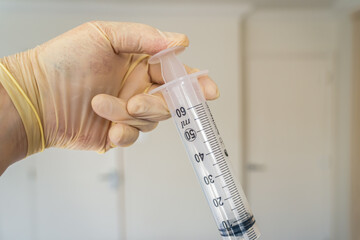  clinical syringe being used to administer a vaccine like coronavirus pandemic covid -19  via an...