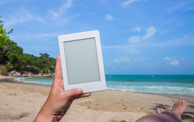 Hands with a white Tablet at a beach at ko Phangan, Thailand
