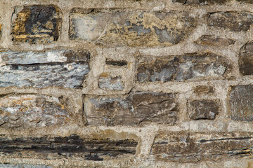 pattern brown color of old stone wall uneven cracked real stone wall surface with cement