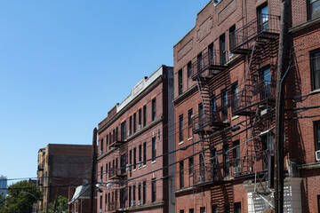 Fototapeta na wymiar Row of Old Brick Apartment Buildings with Fire Escapes in Astoria Queens New York