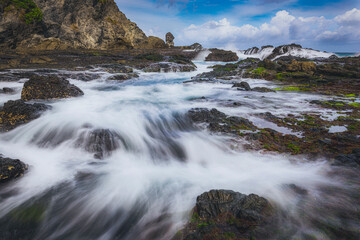 Sea water flowing view in Siung volcanic rock beach, Java Island, Indonesia