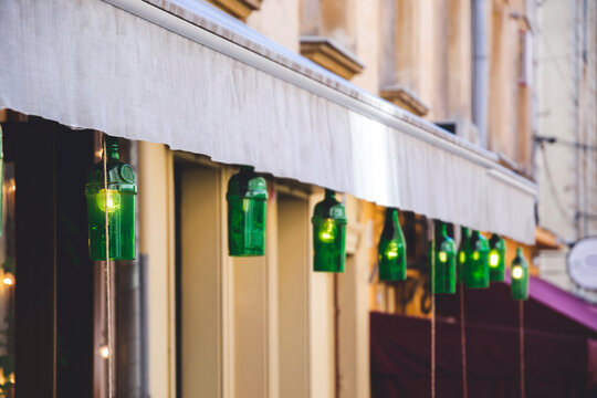 Close up picture of green bottle, as lights for cafe. Handmade lightning on the streets, as eco decoration. Illumination with wine bottles and empty space fro text. Background for restaurant. 