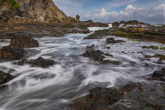 Sea water flowing view in Siung volcanic rock beach, Java Island, Indonesia