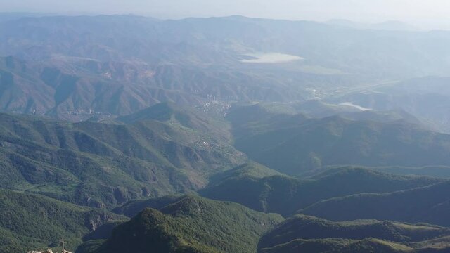 Aerial view green mountains and rocks.  Drone fly over Khustup, Syuniq province, Armenia. In background Kapan city.