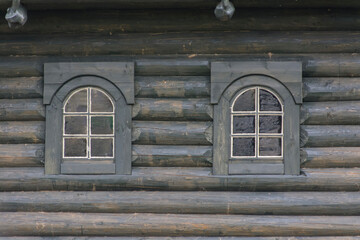 two windows in an old wooden house made of planed logs