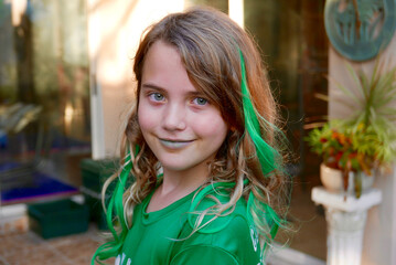 Smiling girl with green clothing, green lips, and green extensions in her hair
