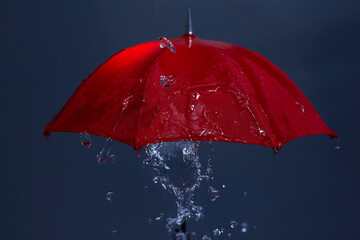 Rain drops falling from red umbrella. Bad weather concept.