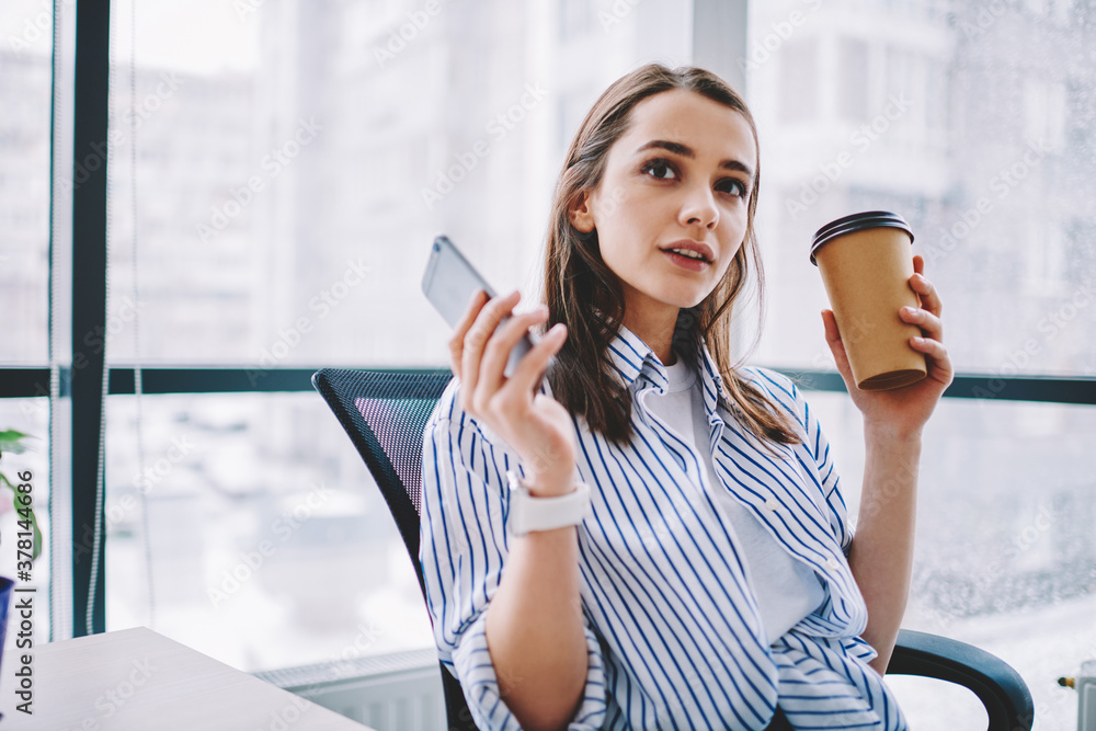 Poster pensive caucasian employee in smart casual clothing using cellular application for social networking