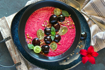 Fresh smoothie with cherries, grapes and sunflower seeds on dark background. Diet food. Top view with copy space.