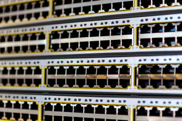 A stack of network switches with empty ports exposed just removed from a server cabinet in an office.