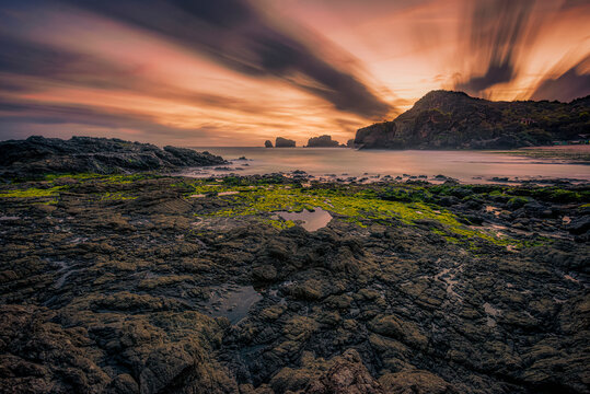 Beautiful of Siung beach landscape view in long exposure shot with motion blur cloud background