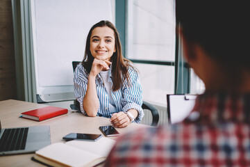 Selective focus on successful woman listening male colleague during positive conversation in...