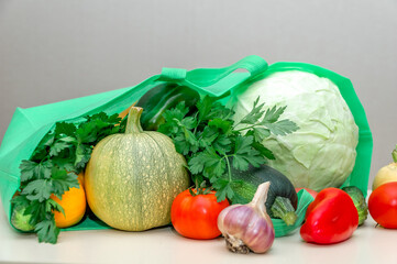 Green bag with fresh vegetables and herbs. Harvesting. Home delivery. Correct healthy diet.