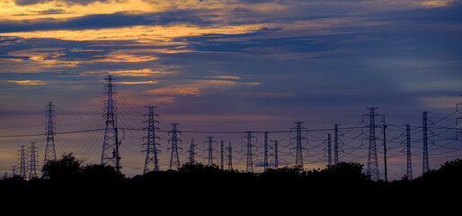 silhouette Electric transmission pole with sunset in the sky