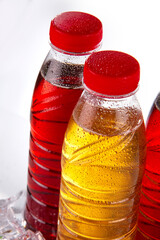 Three bottles with ice tea, decorated with ice cubes and tea leaves