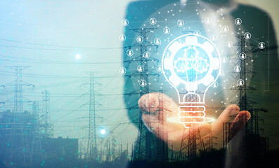 Double exposure of business man holding lamp with Electric transmission pole with sunset in the...