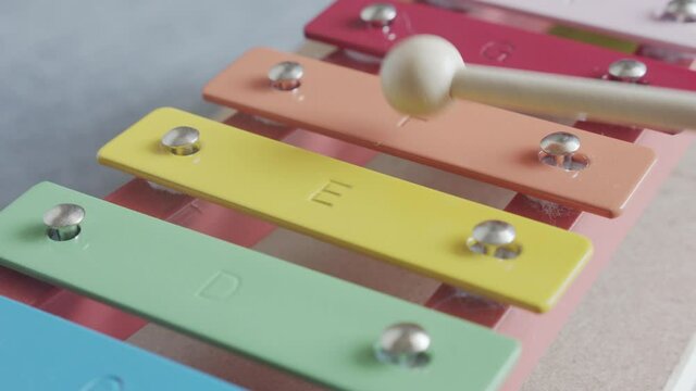 Mallet over child xylophone toy close-up footage